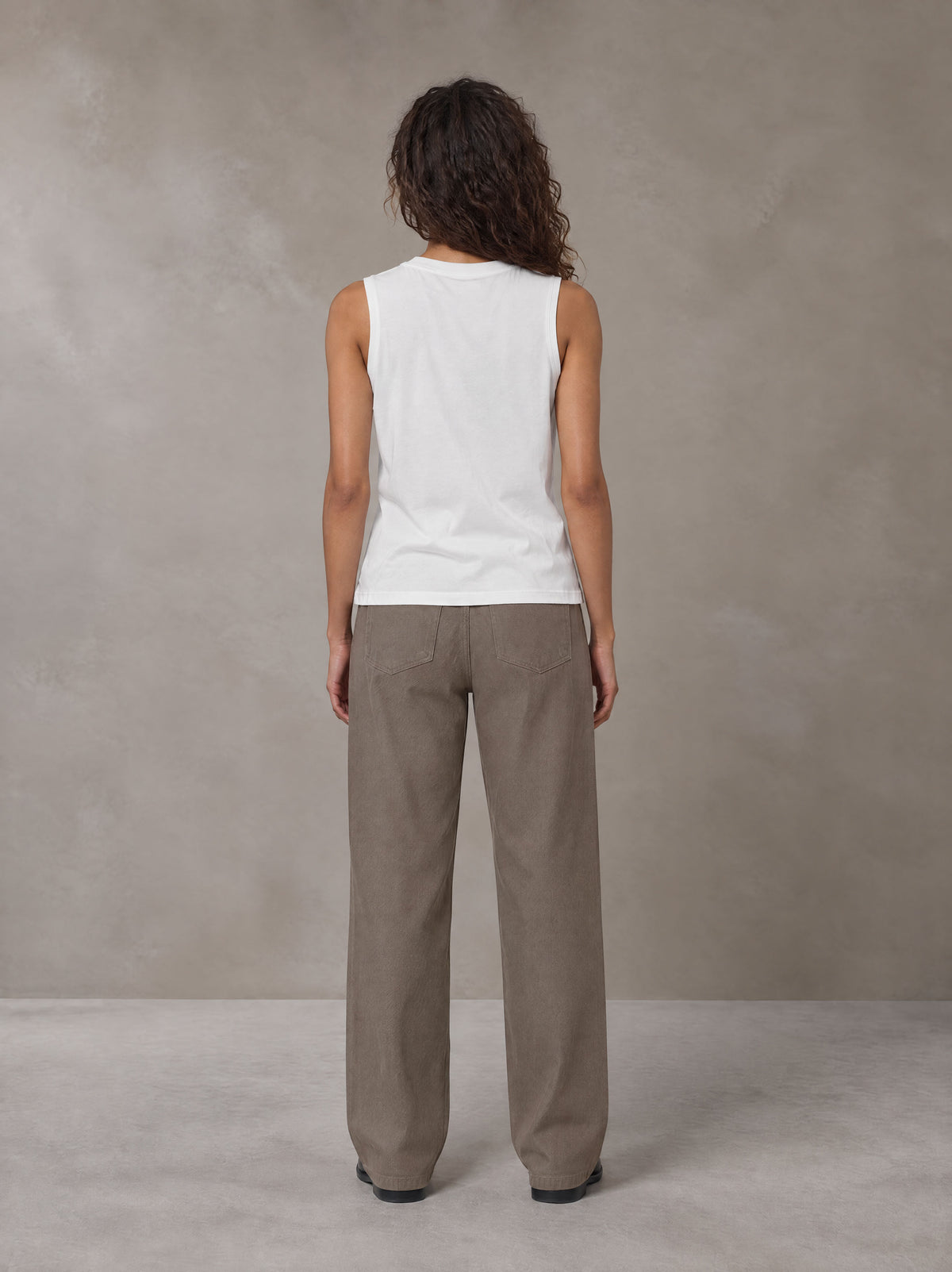 Model wearing SM Sig. Sleeveless Tank Top in Ivory White, rear view.