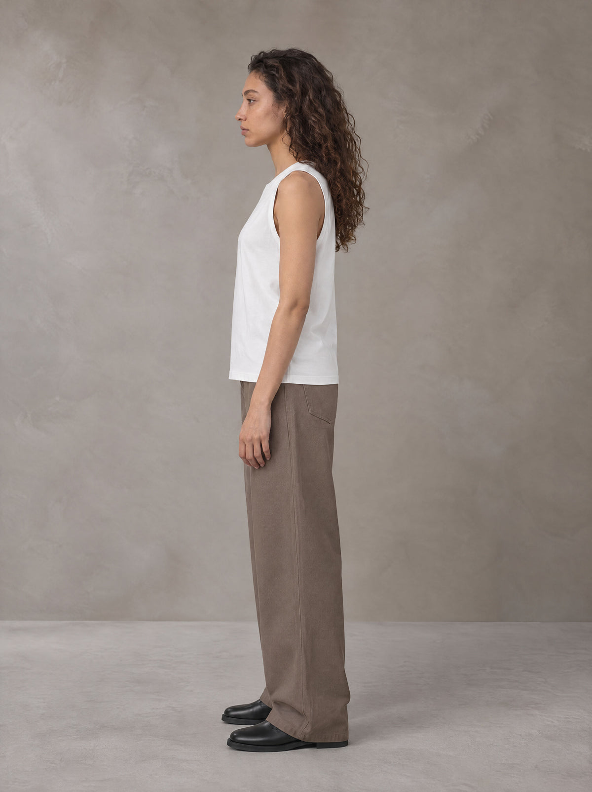 Model wearing SM Sig. Sleeveless Tank Top in Ivory White, side profile.