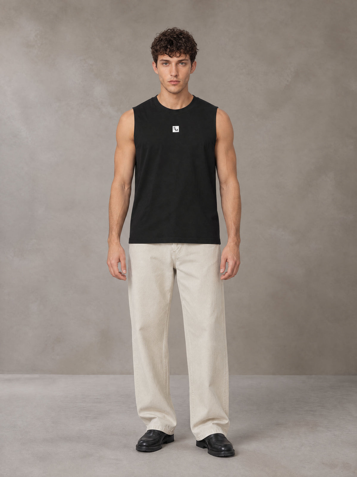 Model wearing SM Sig. Sleeveless Tank Top in Midnight Black, front view.