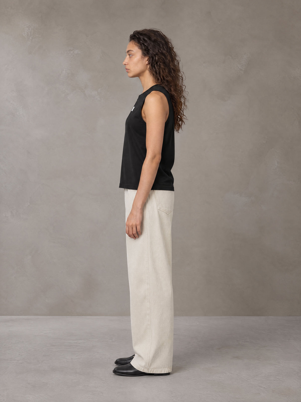 Model wearing SM Sig. Sleeveless Tank Top in Midnight Black, side profile.