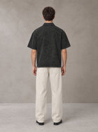 Model wearing SM Sig. Snow Washed Polo T-shirt in Midnight Black, rear view.