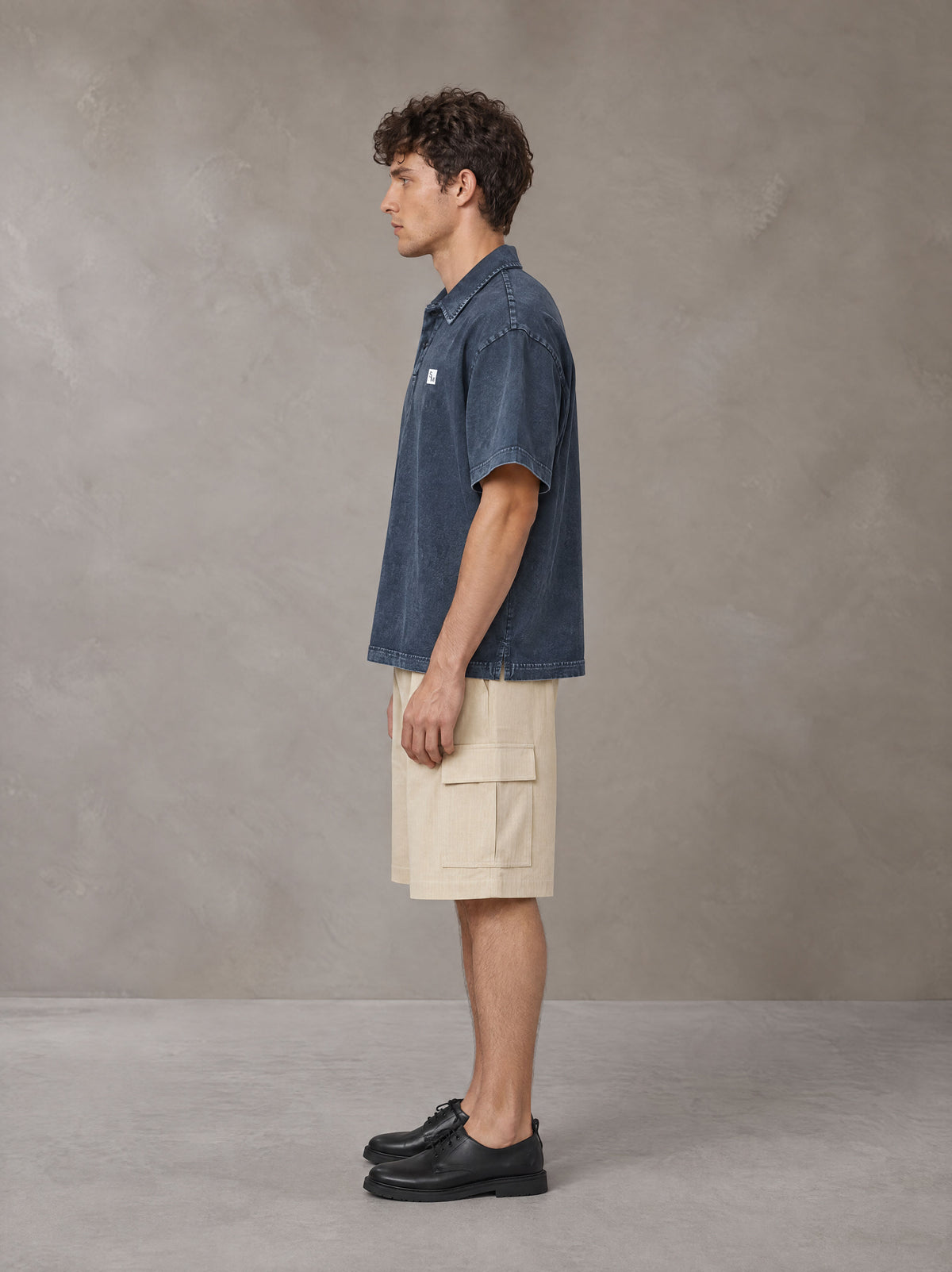 Model wearing SM Sig. Snow Washed Polo T-shirt in Oxford Navy, side profile.