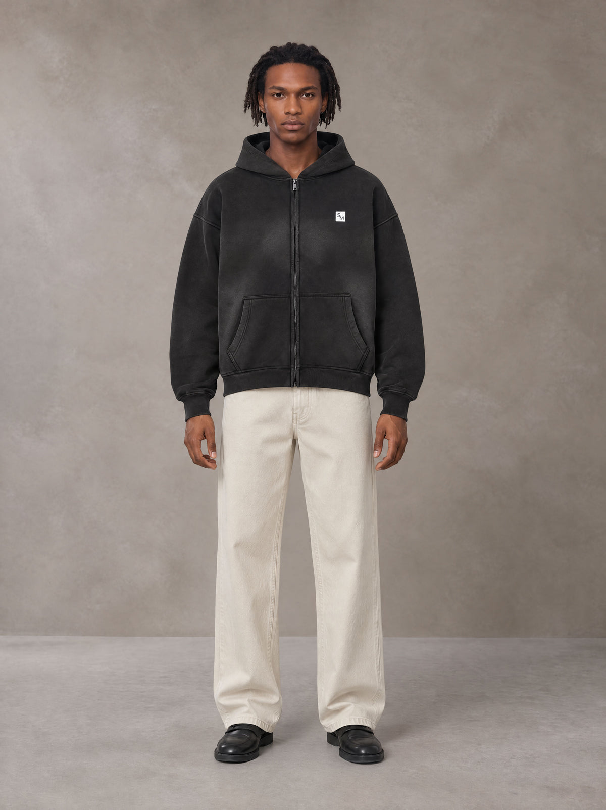 Model wearing SM Sig. Washed Boxy Hoodie in Midnight Black, front view.