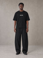 Model wearing SM Silk Logo T-shirt in Midnight Black, front view.