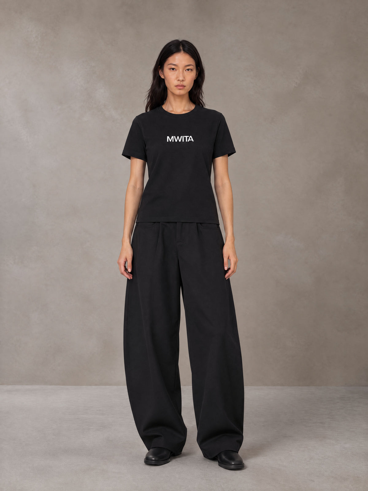 Model wearing SM Silk Logo T-shirt in Midnight Black, front view.