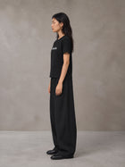 Model wearing SM Silk Logo T-shirt in Midnight Black, side profile.