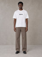 Model wearing SM Silk Logo T-shirt in Lucent White, front view.