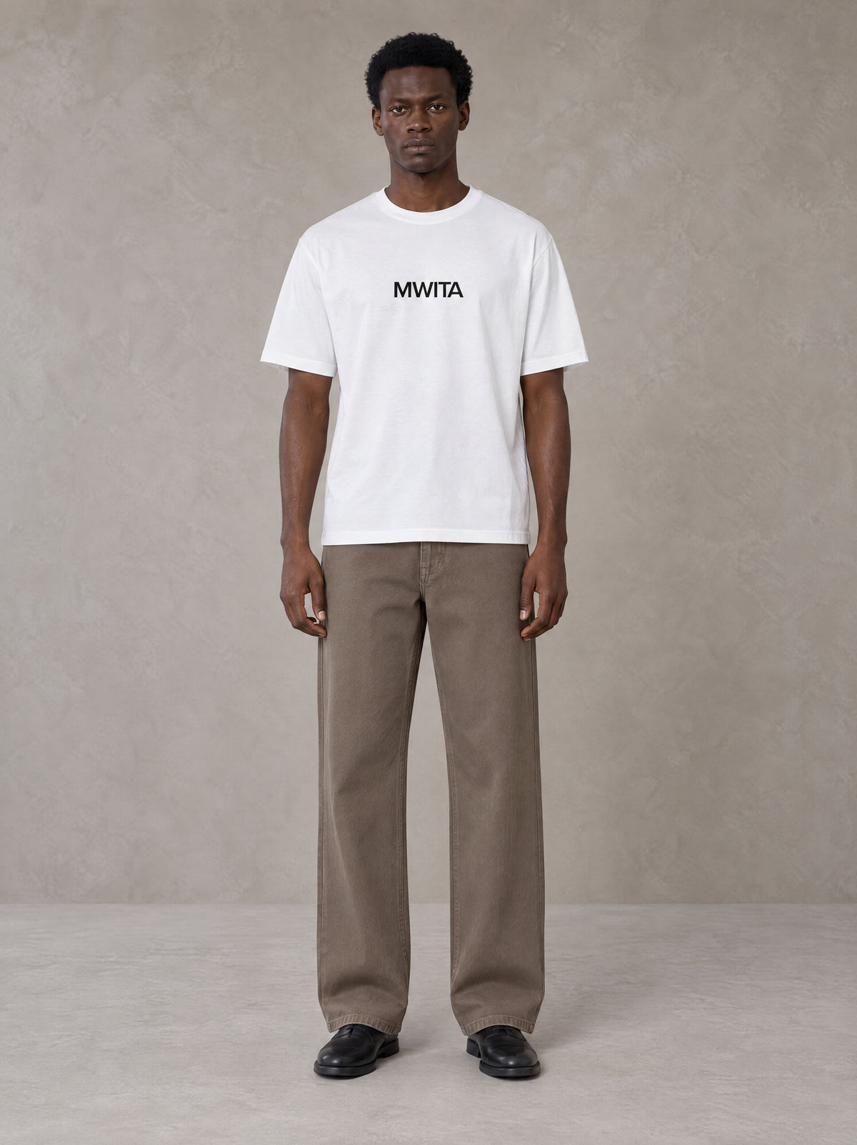 Model wearing SM Silk Logo T-shirt in Lucent White, front view.