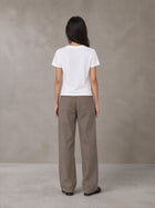 Model wearing SM Silk Logo T-shirt in Lucent White, rear view.