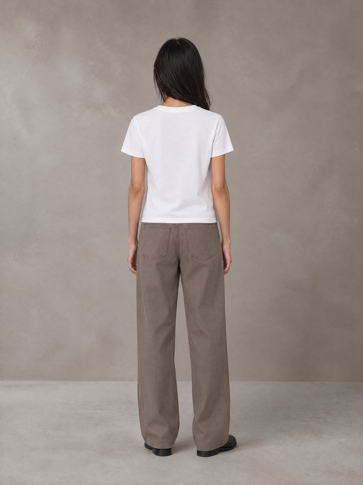 Model wearing SM Silk Logo T-shirt in Lucent White, rear view.