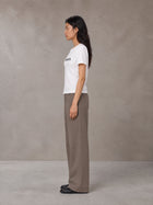 Model wearing SM Silk Logo T-shirt in Lucent White, side profile.