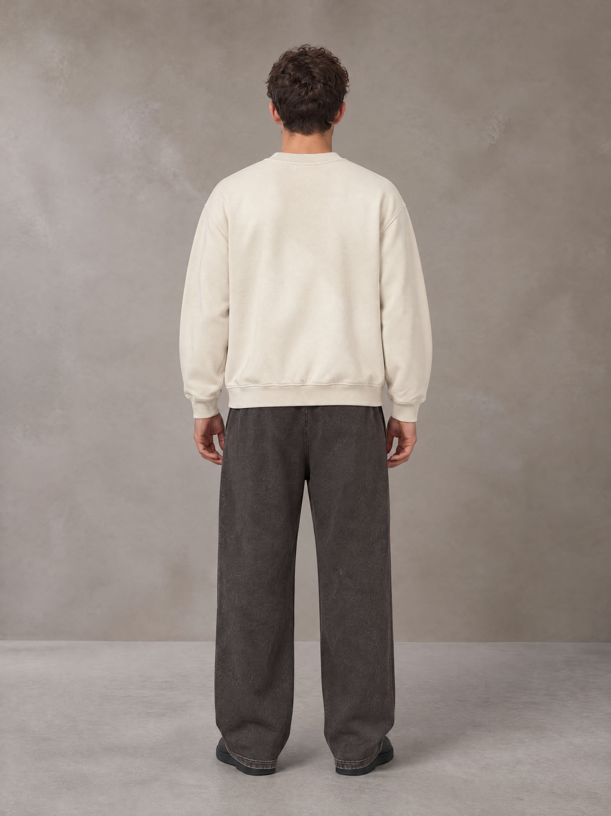Model wearing SM Sunfade Fleeced Sweatshirt in Classic Cream, rear view.