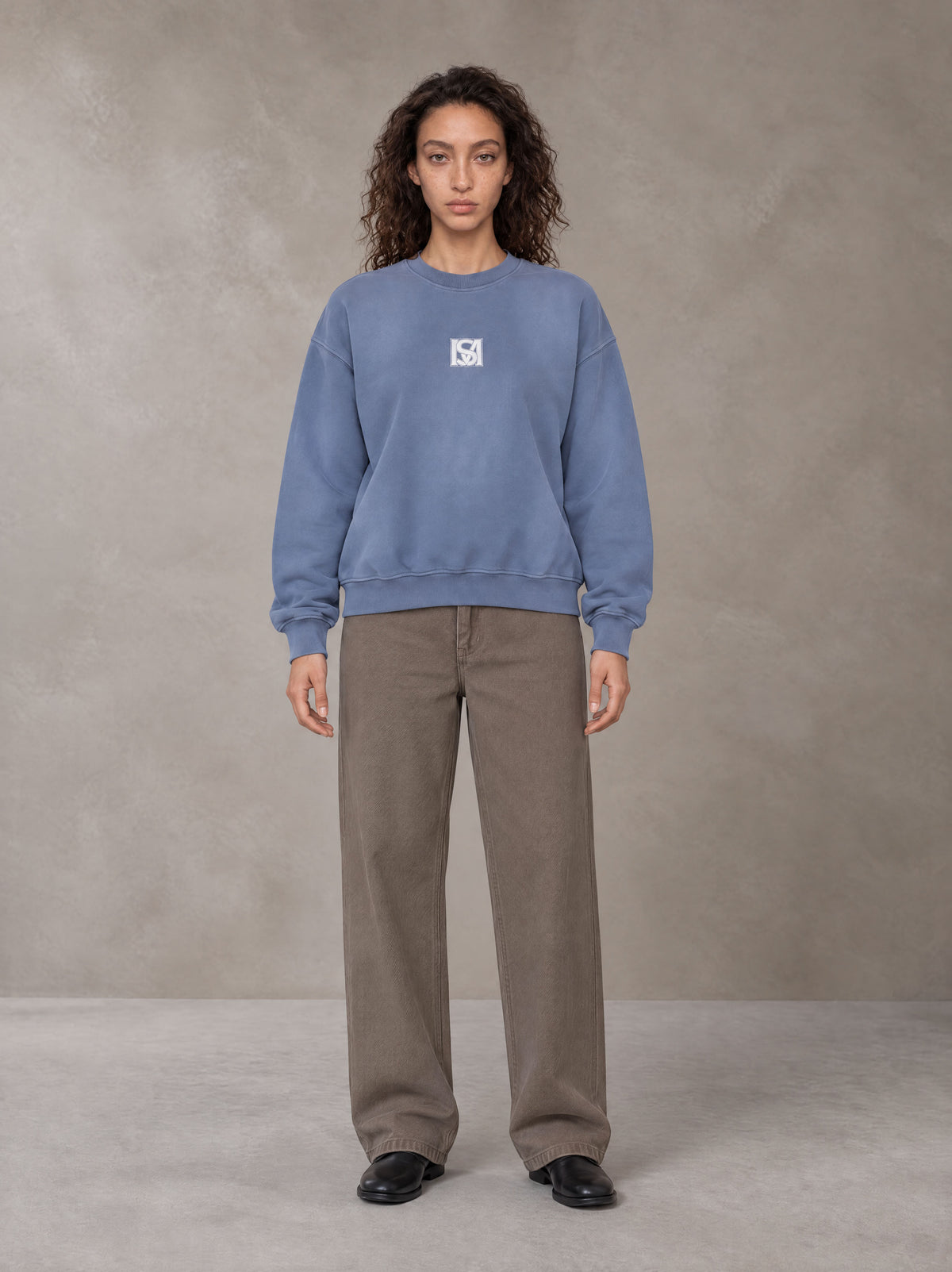 Model wearing SM Sunfade Fleeced Sweatshirt in Deep Denim, front view.