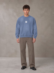 Model wearing SM Sunfade Fleeced Sweatshirt in Deep Denim, front view.