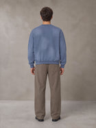 Model wearing SM Sunfade Fleeced Sweatshirt in Deep Denim, rear view.