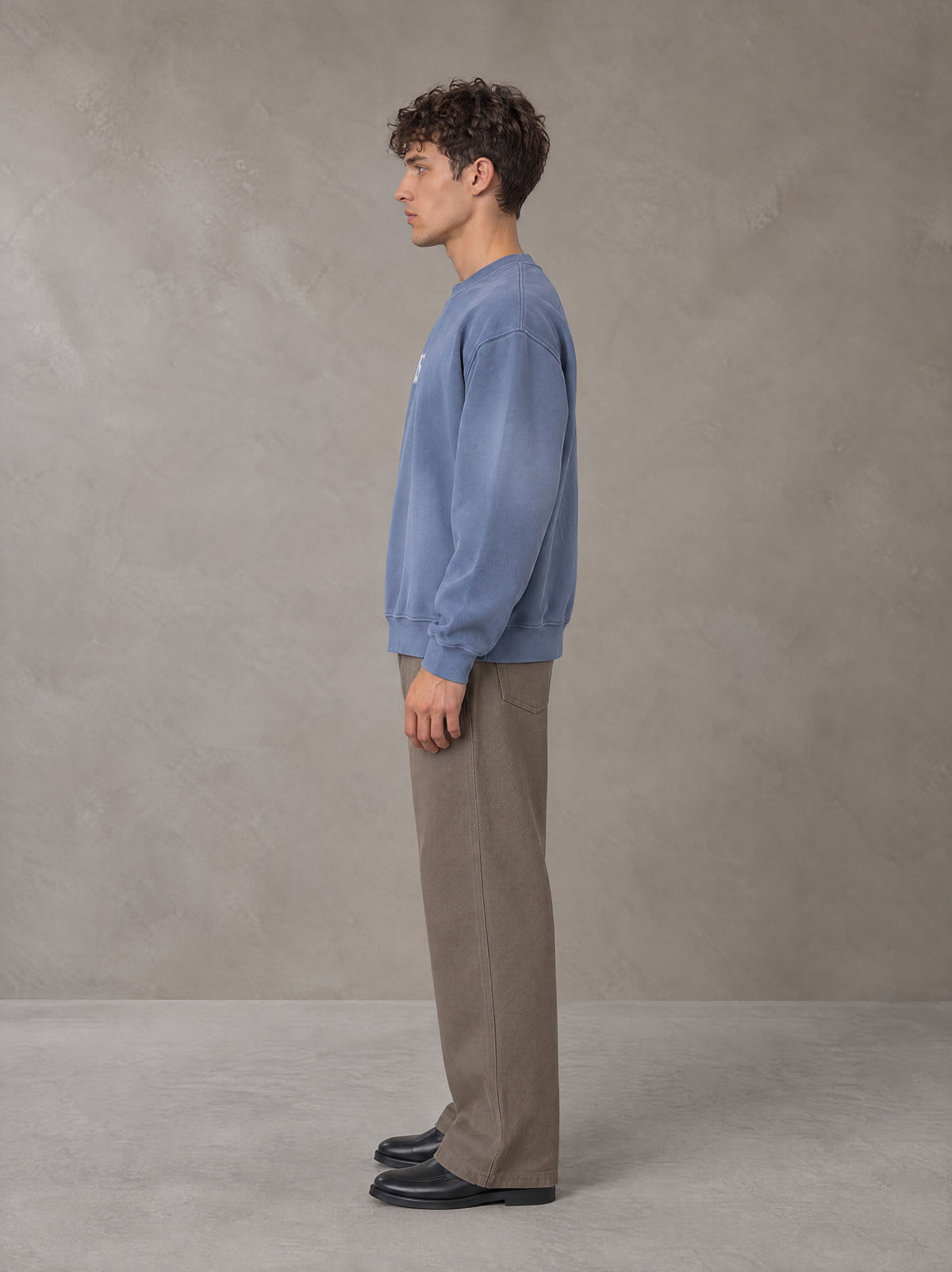 Model wearing SM Sunfade Fleeced Sweatshirt in Deep Denim, side profile.