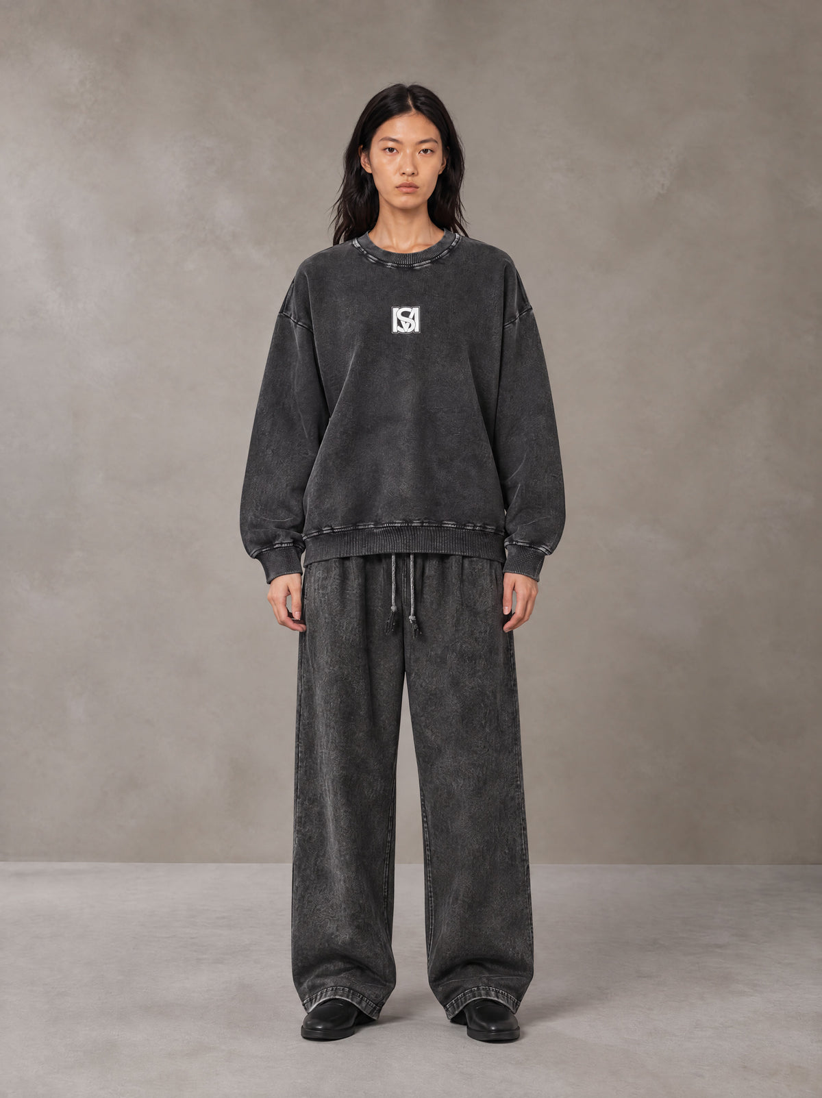 Model wearing the SM Acid Wash Sweatshirt and SM Acid Wash Trousers in Midnight Black, front view.