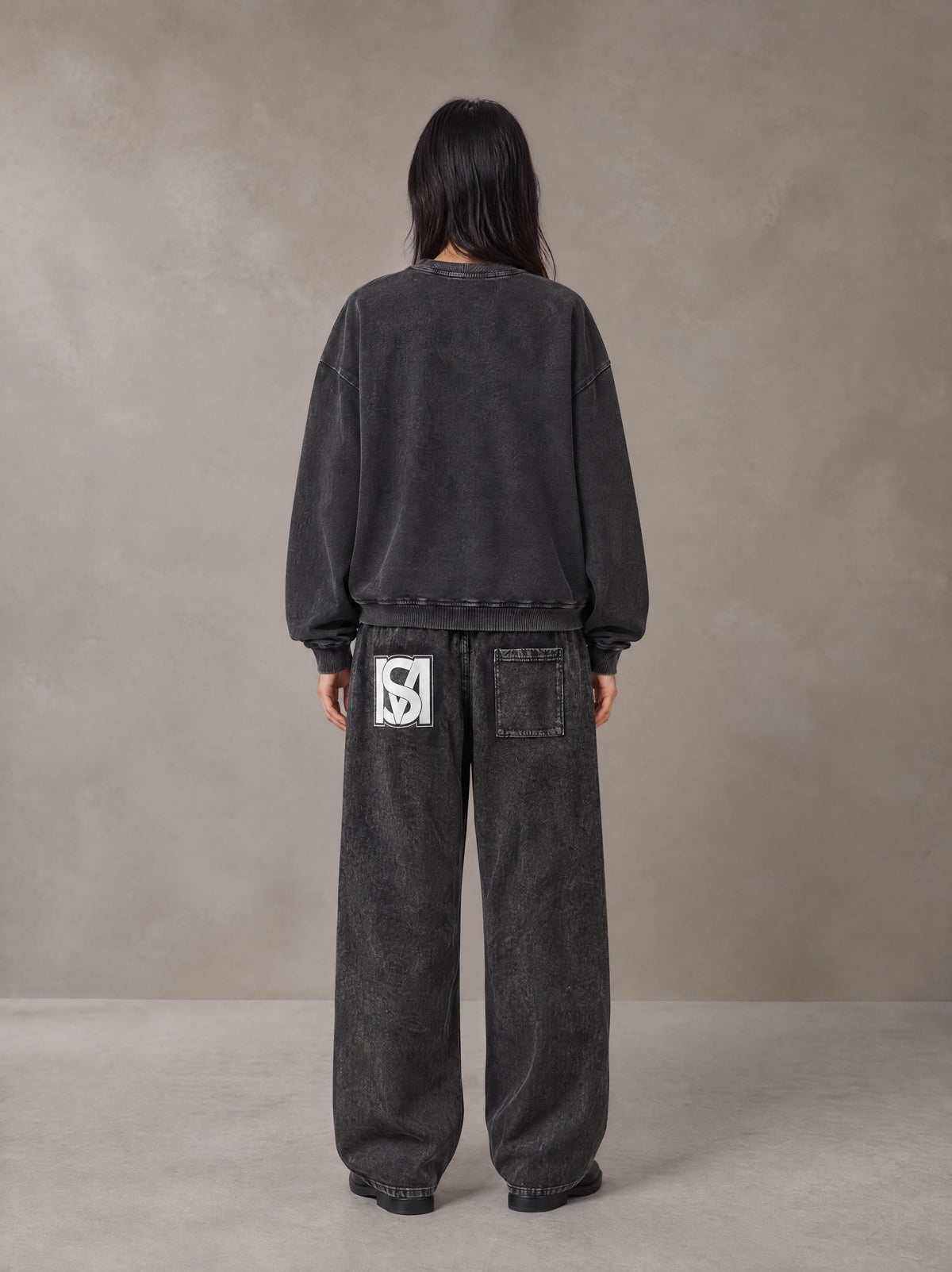Model wearing the SM Acid Wash Sweatshirt and SM Acid Wash Trousers in Midnight Black, rear view.