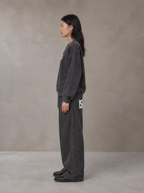 Model wearing the SM Acid Wash Sweatshirt and SM Acid Wash Trousers in Midnight Black, side profile.