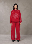 Model wearing the SM Fleur Eclipse Jacket and SM Fleur Eclipse Sweatpants in Crimson, front view.