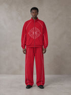 Model wearing the SM Fleur Eclipse Jacket and SM Fleur Eclipse Sweatpants in Crimson, front view.