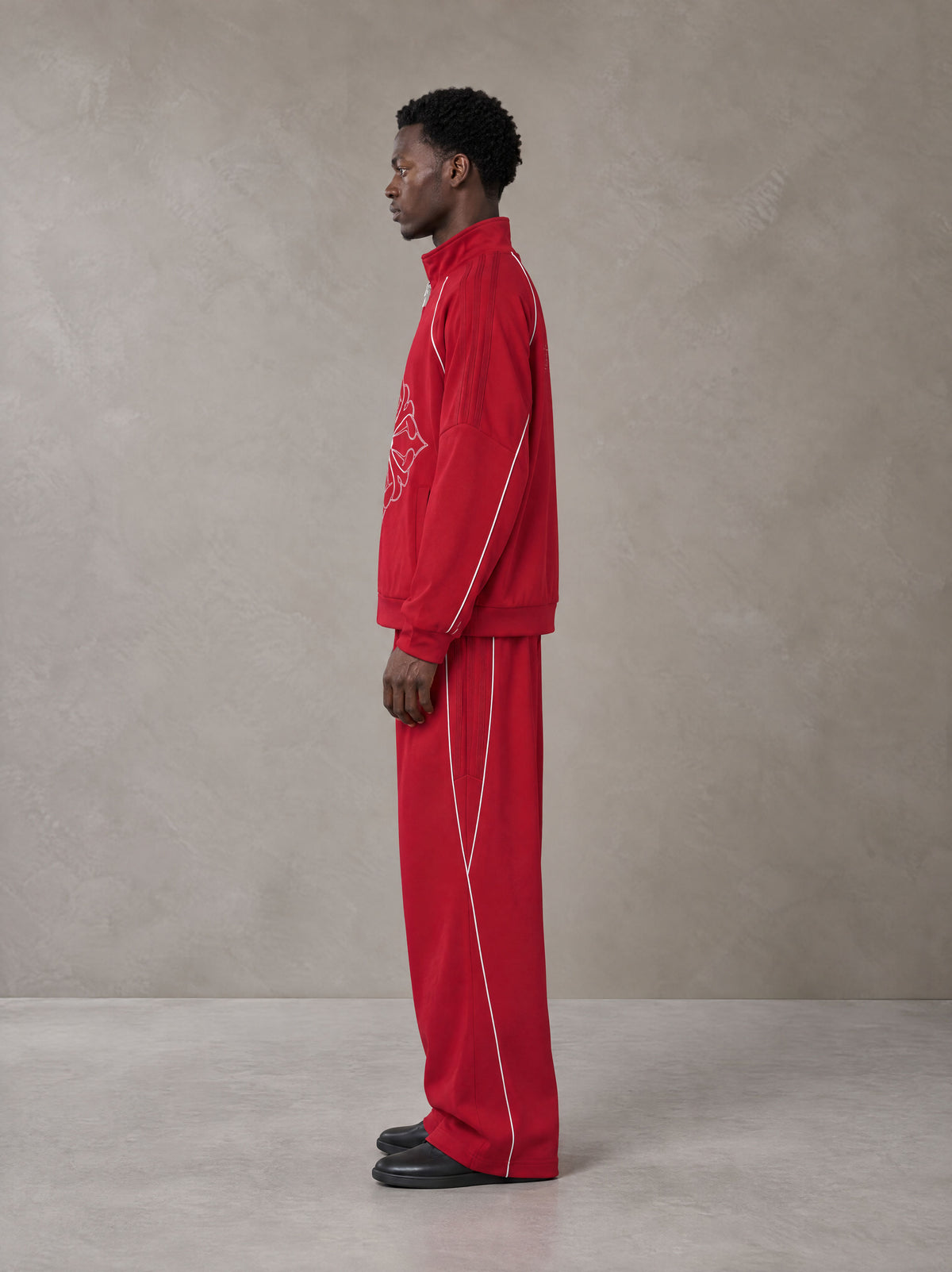 Model wearing the SM Fleur Eclipse Jacket and SM Fleur Eclipse Sweatpants in Crimson, side profile.