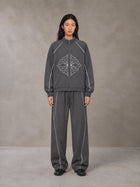 Model wearing the SM Fleur Eclipse Jacket and SM Fleur Eclipse Sweatpants in Deep Charcoal, front view.