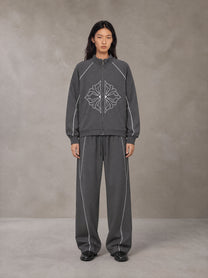 Model wearing the SM Fleur Eclipse Jacket and SM Fleur Eclipse Sweatpants in Deep Charcoal, front view.