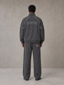 Model wearing the SM Fleur Eclipse Jacket and SM Fleur Eclipse Sweatpants in Deep Charcoal, rear view.
