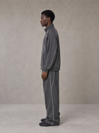 Model wearing the SM Fleur Eclipse Jacket and SM Fleur Eclipse Sweatpants in Deep Charcoal, side profile.