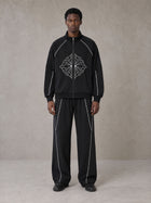 Model wearing the SM Fleur Eclipse Jacket and SM Fleur Eclipse Sweatpants in Midnight Black, front view.
