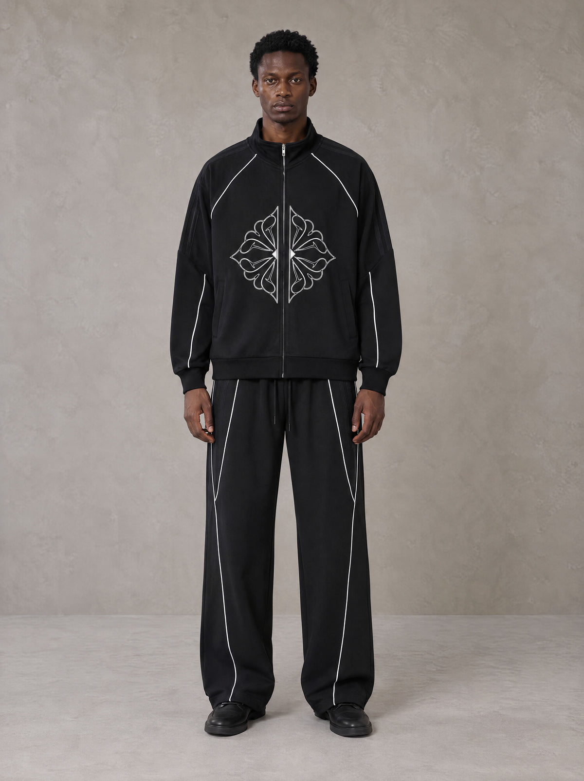 Model wearing the SM Fleur Eclipse Jacket and SM Fleur Eclipse Sweatpants in Midnight Black, front view.