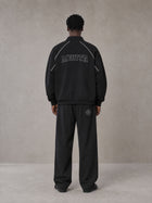Model wearing the SM Fleur Eclipse Jacket and SM Fleur Eclipse Sweatpants in Midnight Black, rear view.