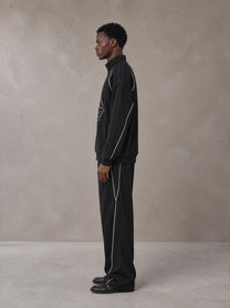 Model wearing the SM Fleur Eclipse Jacket and SM Fleur Eclipse Sweatpants in Midnight Black, side profile.