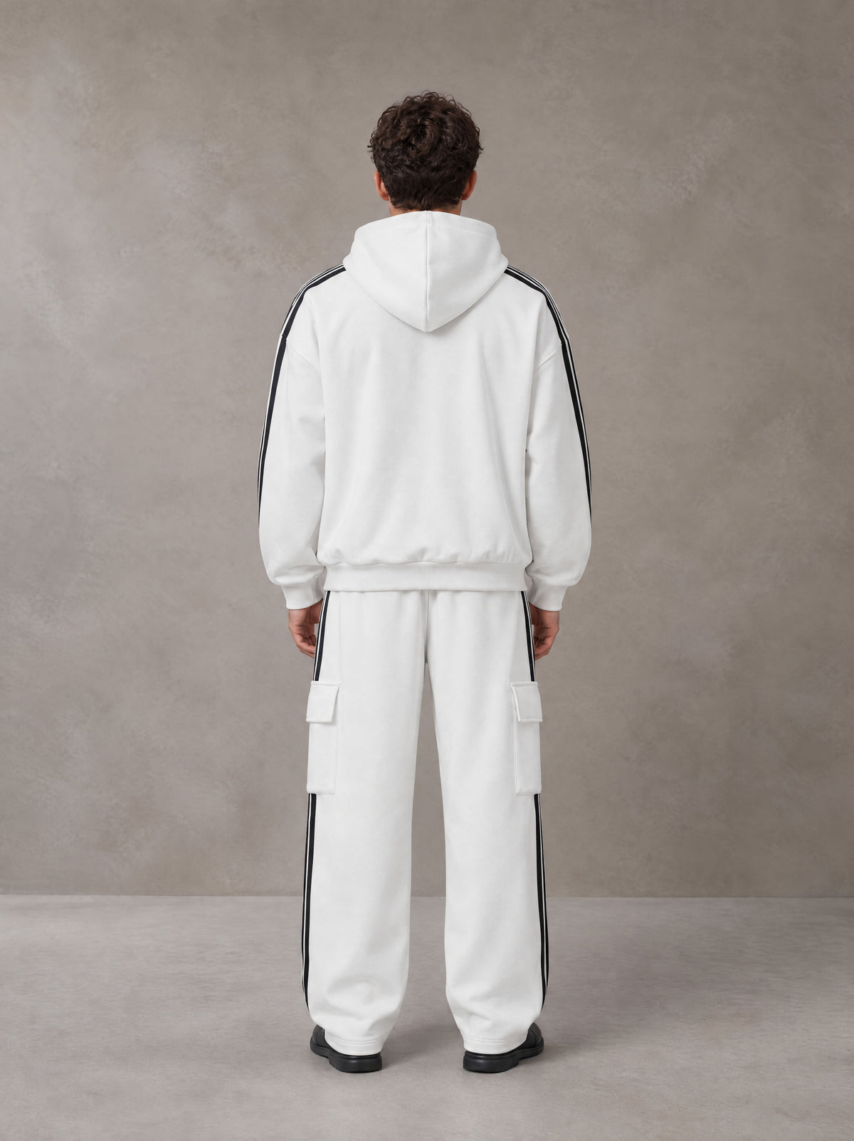 Model wearing the SM Insignia Utility Hoodie and SM Insignia Utility Sweatpants in Lucent White, rear view.