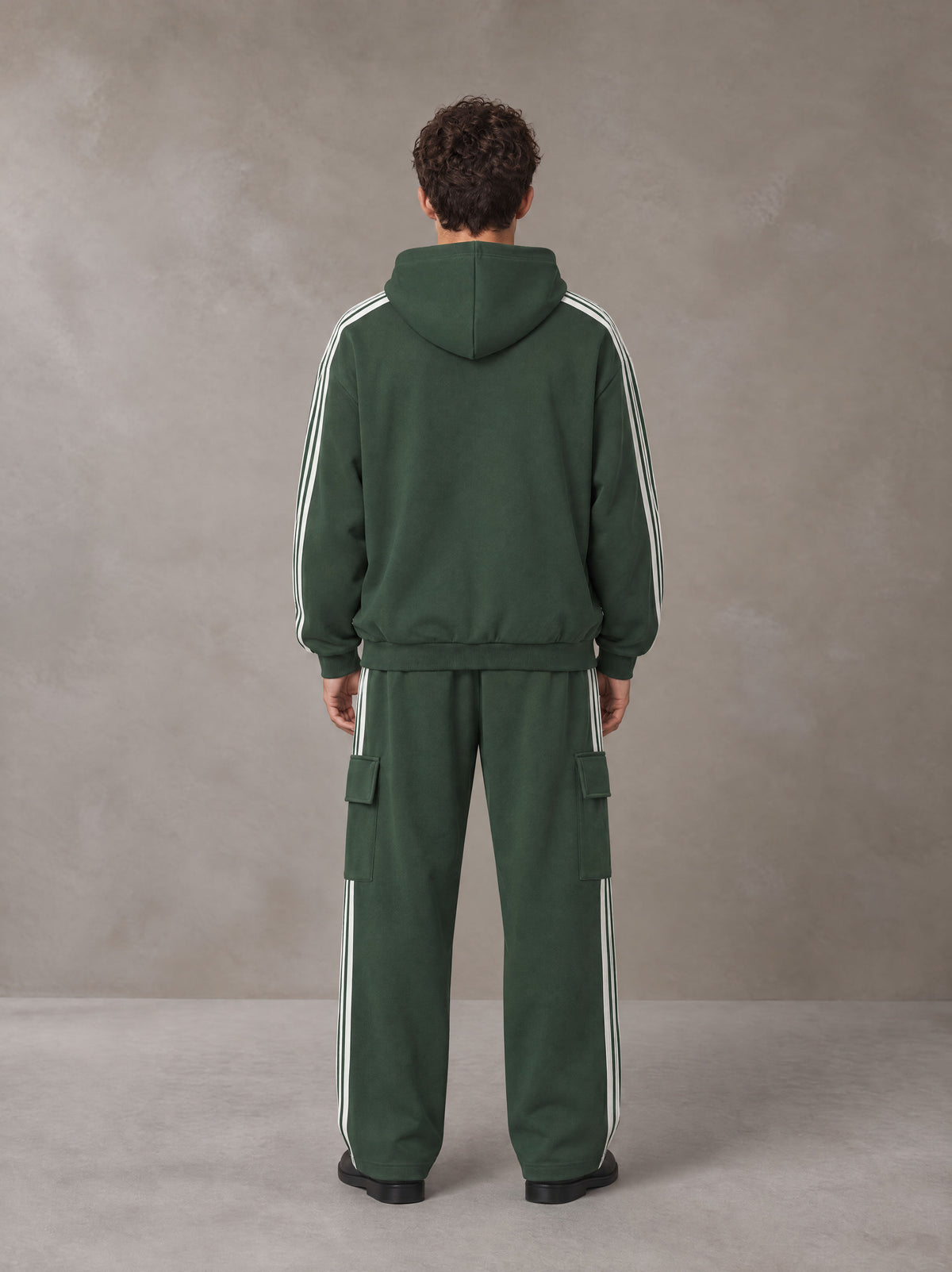 Model wearing the SM Insignia Utility Hoodie and SM Insignia Utility Sweatpants in Lunar Green, rear view.