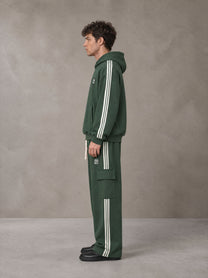 Model wearing the SM Insignia Utility Hoodie and SM Insignia Utility Sweatpants in Lunar Green, side profile.