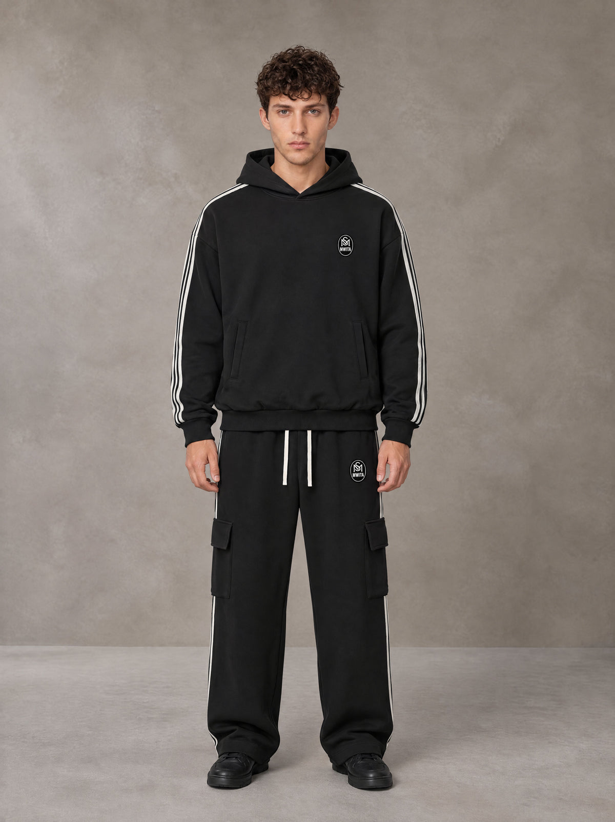 Model wearing the SM Insignia Utility Hoodie and SM Insignia Utility Sweatpants in Midnight Black, front view.