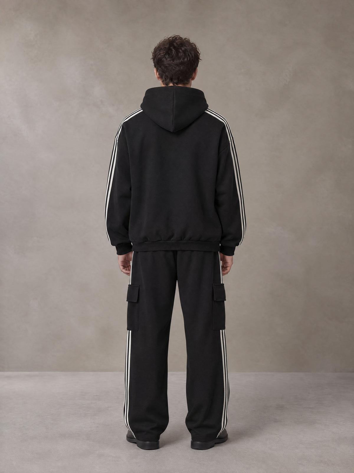 Model wearing the SM Insignia Utility Hoodie and SM Insignia Utility Sweatpants in Midnight Black, rear view.