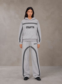 Model wearing the SM Track Line Hoodie and SM Track Line Sweatpants in Floral Grey, front view.