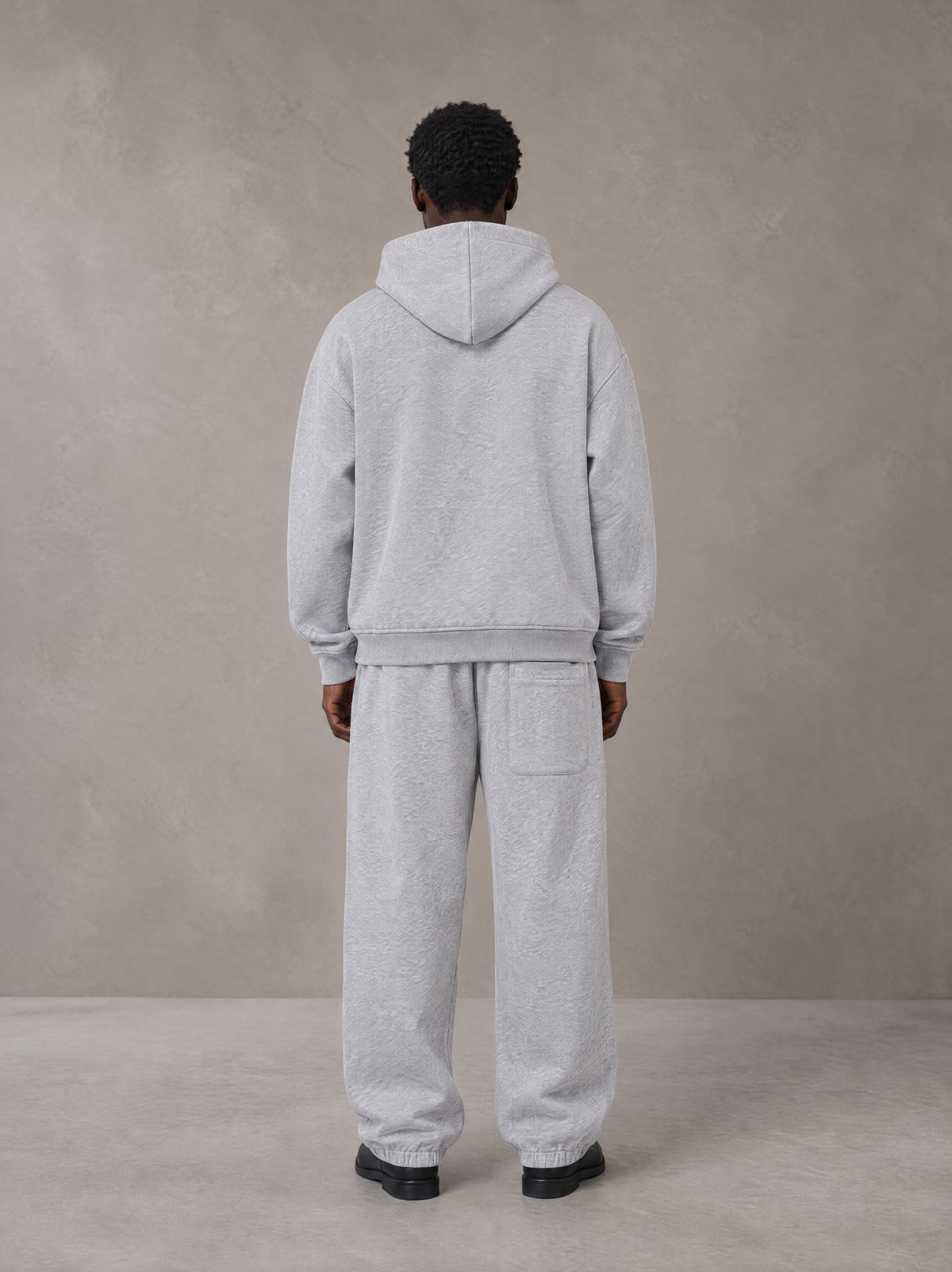 Model wearing the SM Track Line Hoodie and SM Track Line Sweatpants in Floral Grey, rear view.
