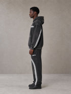 Model wearing the SM Track Line Hoodie and SM Track Line Sweatpants in Midnight Black, side profile.