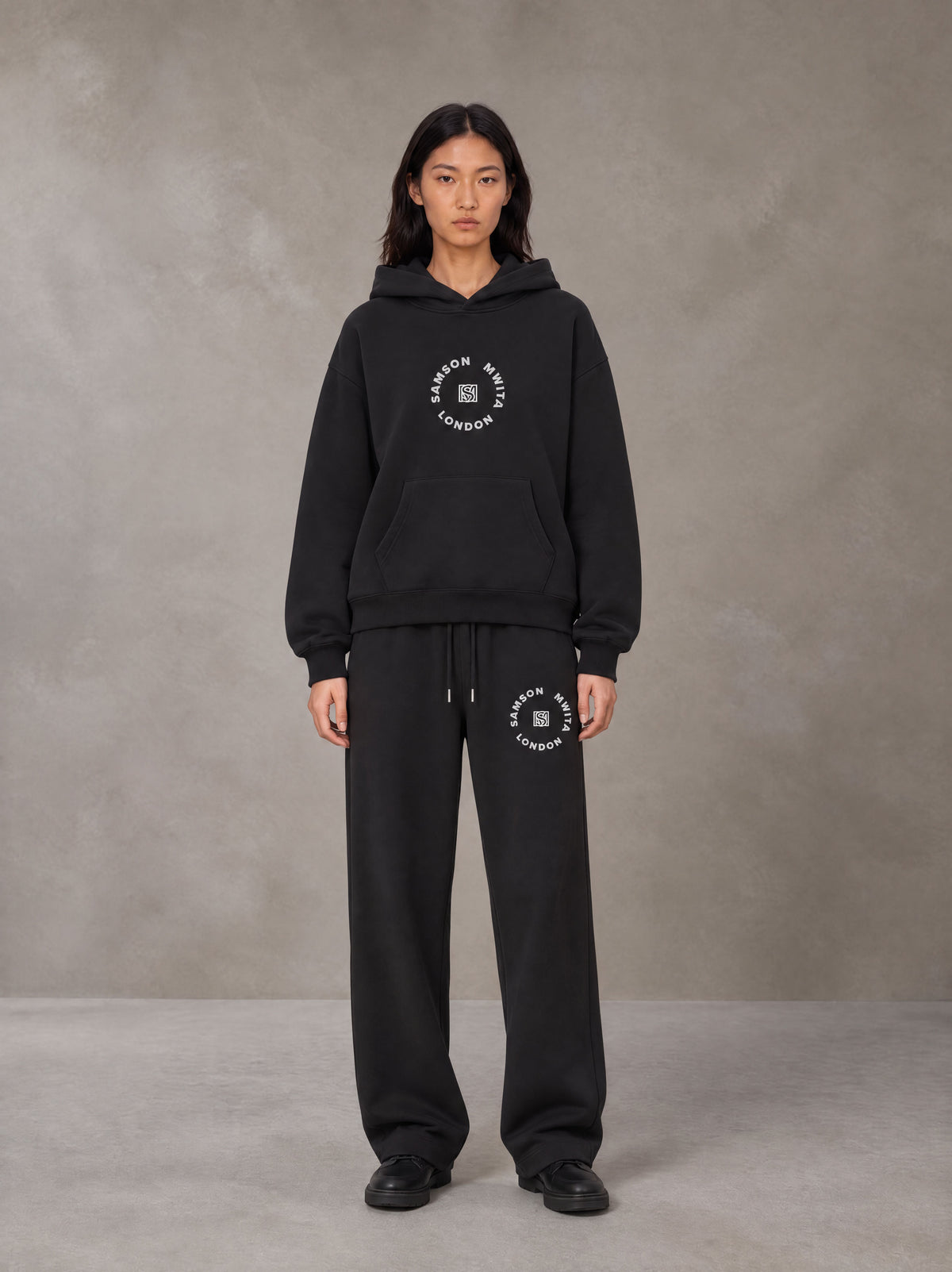 Model wearing the SM London Hoodie and SM London Sweatpants in Deep Charcoal, front view.