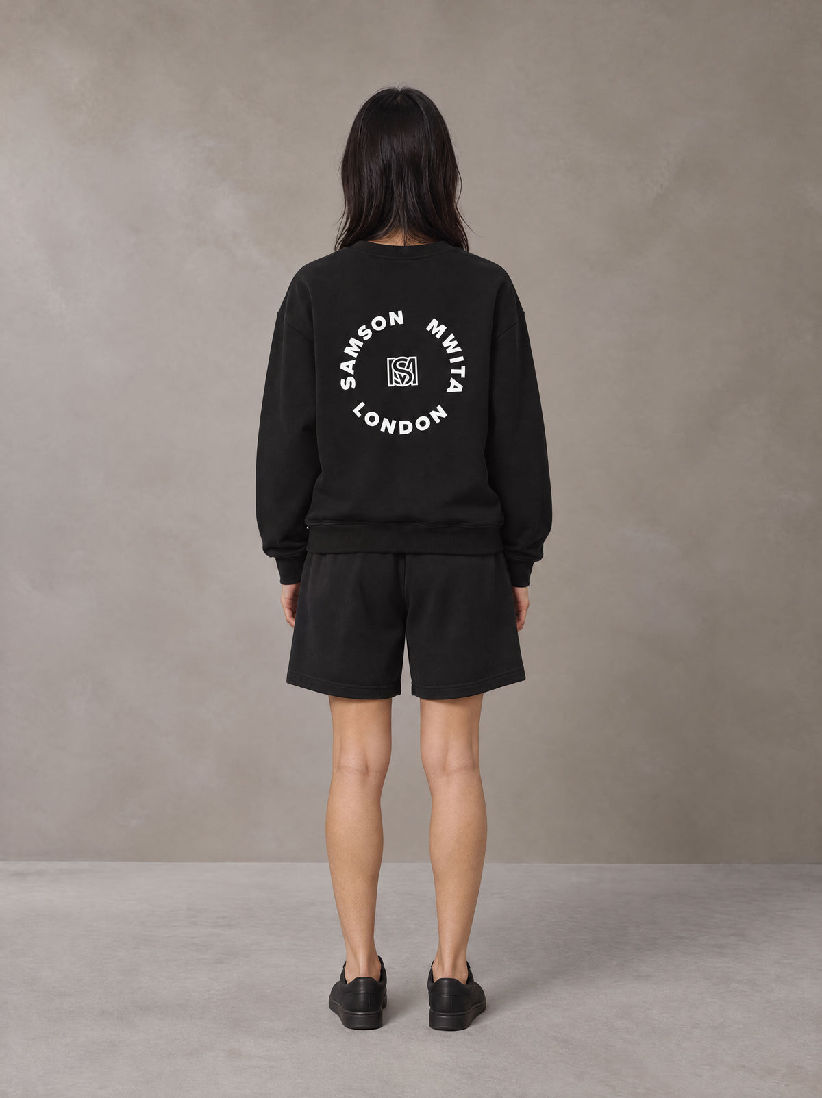 Model wearing the SM London Sweatshirt and SM London Shorts in Midnight Black, rear view.