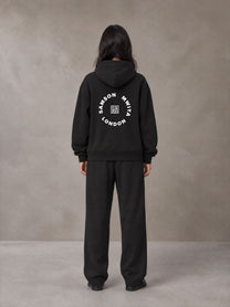 Model wearing the SM London Hoodie and SM London Sweatpants in Midnight Black, rear view.