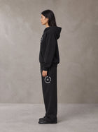 Model wearing the SM London Hoodie and SM London Sweatpants in Midnight Black, side profile.