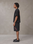 Model wearing the SM Echo Fleur T-shirt and SM Echo Fleur Shorts in Midnight Black, side profile.