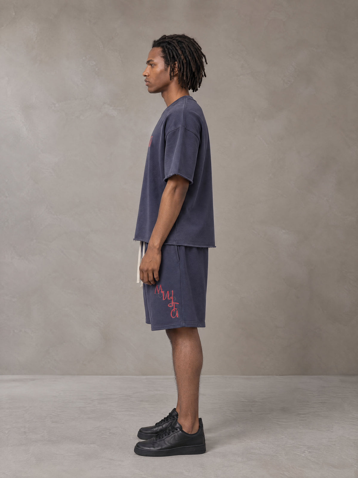 Model wearing the SM Echo Fleur T-shirt and SM Echo Fleur Shorts in Oxford Navy, side profile.