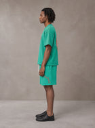 Model wearing the SM Echo Fleur T-shirt and SM Echo Fleur Shorts in Spring Shade, side profile.