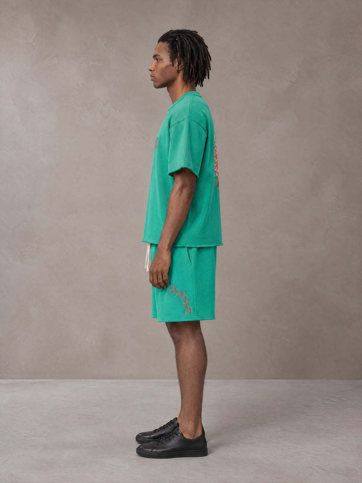 Model wearing the SM Echo Fleur T-shirt and SM Echo Fleur Shorts in Spring Shade, side profile.